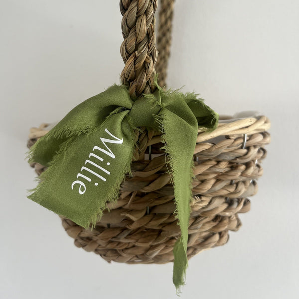 Woven basket with a green ribbon and 'Mille' text on a white background