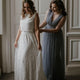 A Bride wearing a Cropped Lace Top and Lace Skirt that is being zipped up by her Bridesmaid in a blue dress.